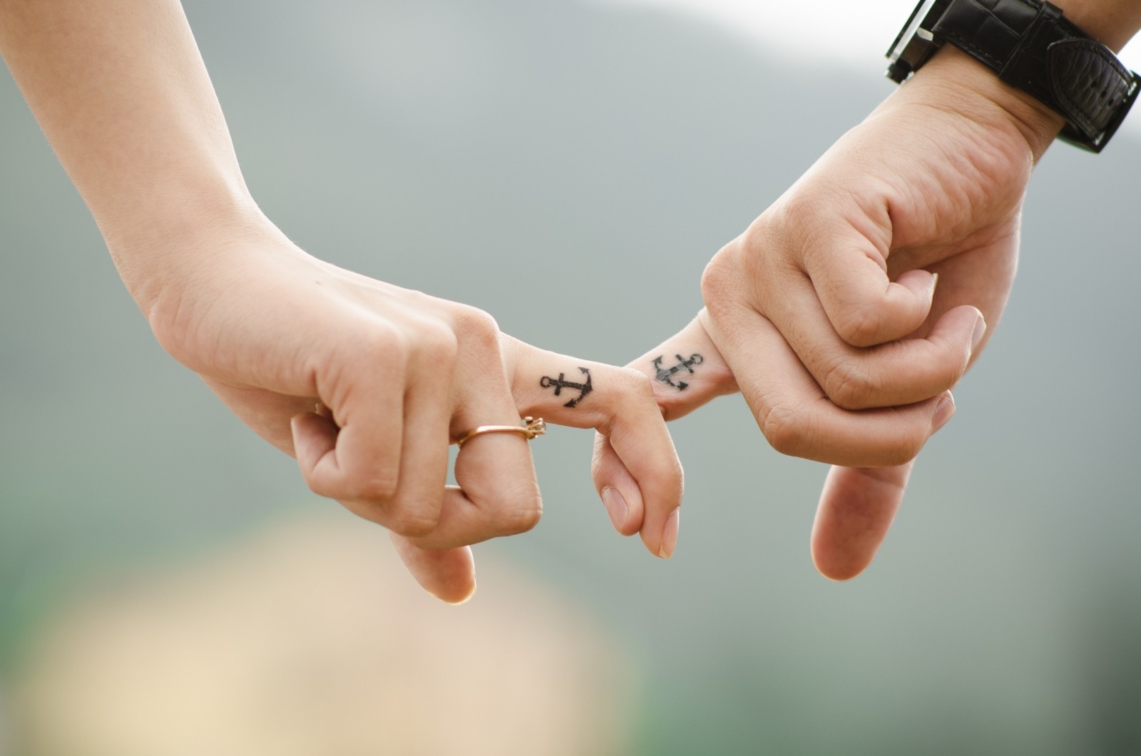 1-young-couple-holding-hands-with-tatoos-on-fingers