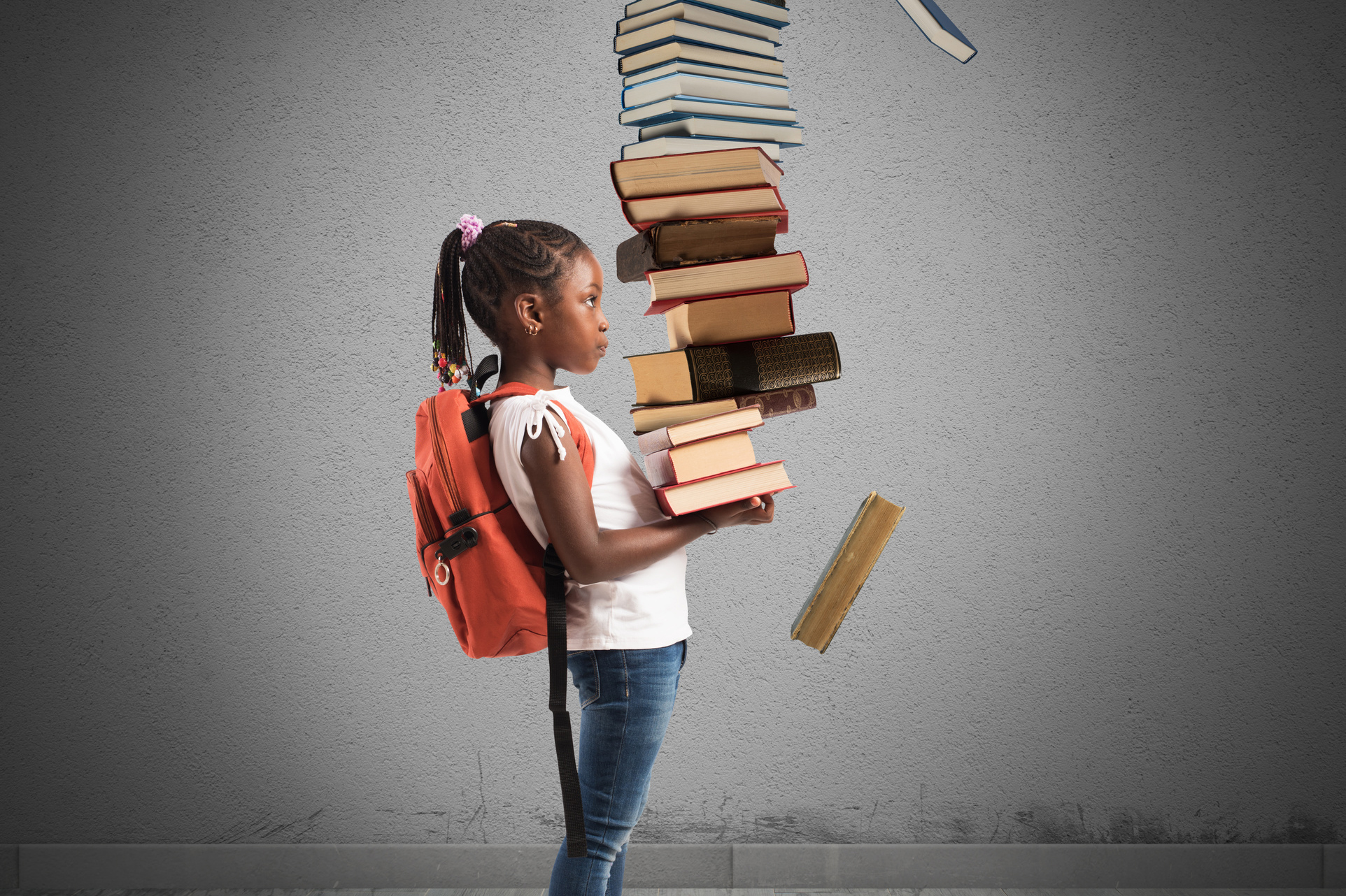 Child with backpack and a books pile