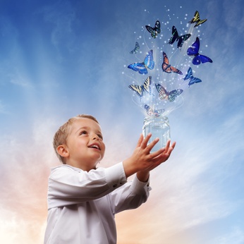 Boy releasing butterflies into the air concept for freedom, peace and spirituality